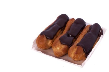 Beyaz izole tatlı üç çikolata eklerleri. Geleneksel Fransız pastaları choux hamur pişmiş bir krem ile dolu