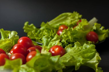Sağlıklı vejetaryen salata domates ve marul üzerine siyah plaka
