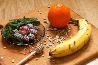 muz, portakal, dondurulmuş çilek böğürtlen ve tohum canlı smoothie maddeler arka planda