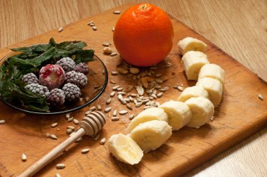 muz, portakal, dondurulmuş çilek böğürtlen ve tohum canlı smoothie maddeler arka planda