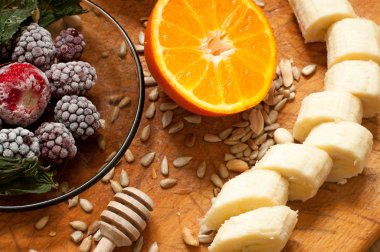 muz, portakal, dondurulmuş çilek böğürtlen ve tohum canlı smoothie maddeler arka planda