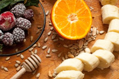 muz, portakal, dondurulmuş çilek böğürtlen ve tohum canlı smoothie maddeler arka planda