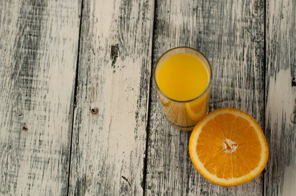 Turuncu meyve kesme ve ahşap masa arka plan üzerine portakal suyu,