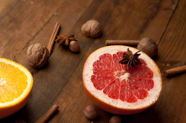 Fatias de laranjas, limões e toranjas na mesa de madeira vintage. Frutas cítricas com anis estrelado, canela. alimentação saudável com vitaminas naturais . — Fotografia de Stock