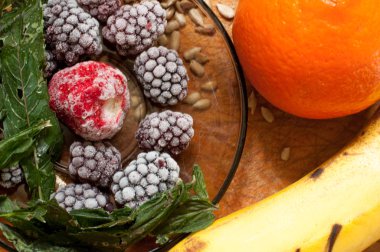 muz, portakal, dondurulmuş çilek böğürtlen ve tohum canlı smoothie maddeler arka planda