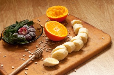 Yemek, el portakal suyu, muz, dondurulmuş çilek böğürtlen ve tohum canlı smoothie maddeler ve blender, meyva suyu sıkacağı, Lale arka plan üzerinde sıkar