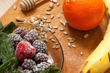 muz, portakal, dondurulmuş çilek böğürtlen ve tohum canlı smoothie maddeler arka planda