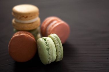 Lezzetli çok renkli pasta macaron veya siyah arka plan üzerine acıbadem kurabiyesi