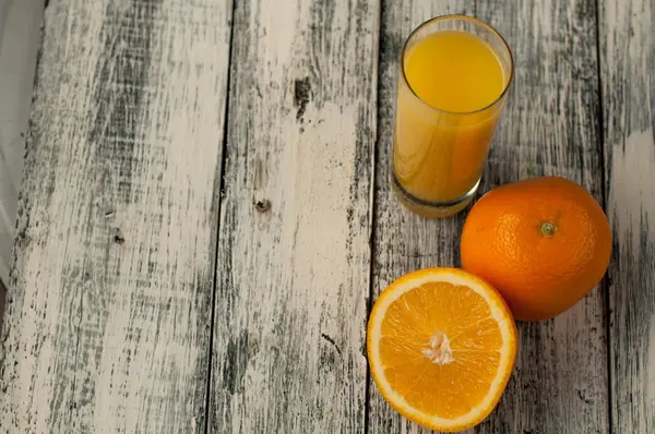 Turuncu meyve kesme ve ahşap masa arka plan üzerine portakal suyu,