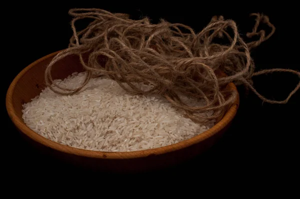 Gros plan riz dans un bol en bois avec cuillère en bois sur fond noir espace vide — Photo
