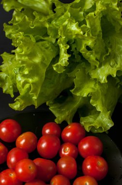 Sağlıklı vejetaryen salata domates ve marul üzerine siyah plaka