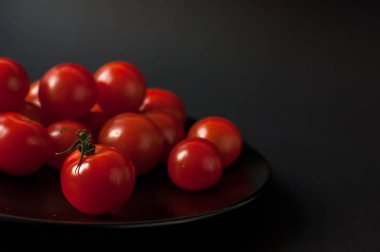 Siyah arkaplanda domatesler.