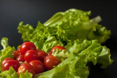 Sağlıklı vejetaryen salata domates ve marul üzerine siyah plaka
