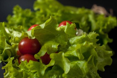 Sağlıklı vejetaryen salata domates ve marul üzerine siyah plaka