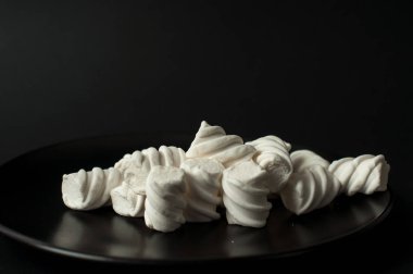 Marshmallow boşaltmak siyah zemin üzerine. Düz yatıyordu veya en iyi görünümü. Arka plan veya doku renkli mini lokum gibiydi.