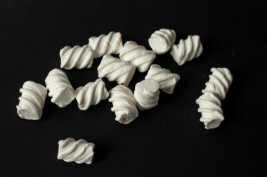 Marshmallow boşaltmak siyah zemin üzerine. Düz yatıyordu veya en iyi görünümü. Arka plan veya doku renkli mini lokum gibiydi.