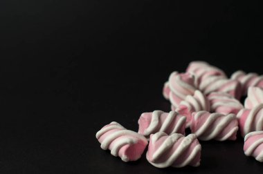 Marshmallow boşaltmak siyah zemin üzerine. Düz yatıyordu veya en iyi görünümü. Arka plan veya doku renkli mini lokum gibiydi.