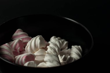 Marshmallow boşaltmak siyah zemin üzerine. Düz yatıyordu veya en iyi görünümü. Arka plan veya doku renkli mini lokum gibiydi.