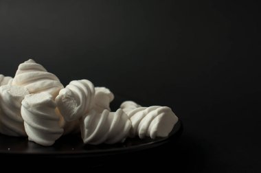 Marshmallow boşaltmak siyah zemin üzerine. Düz yatıyordu veya en iyi görünümü. Arka plan veya doku renkli mini lokum gibiydi.