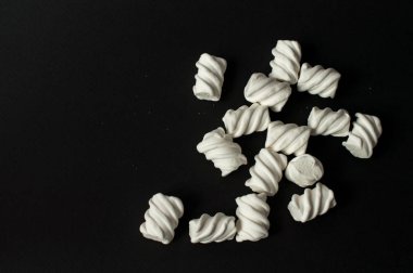 Marshmallow boşaltmak siyah zemin üzerine. Düz yatıyordu veya en iyi görünümü. Arka plan veya doku renkli mini lokum gibiydi.