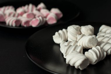 Marshmallow boşaltmak siyah zemin üzerine. Düz yatıyordu veya en iyi görünümü. Arka plan veya doku renkli mini lokum gibiydi.