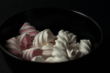 Marshmallow boşaltmak siyah zemin üzerine. Düz yatıyordu veya en iyi görünümü. Arka plan veya doku renkli mini lokum gibiydi.