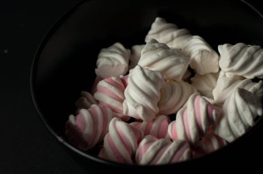 Marshmallow boşaltmak siyah zemin üzerine. Düz yatıyordu veya en iyi görünümü. Arka plan veya doku renkli mini lokum gibiydi.