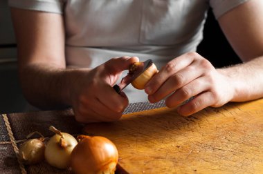 Adam bir bıçak temizler ve soğan kesmek