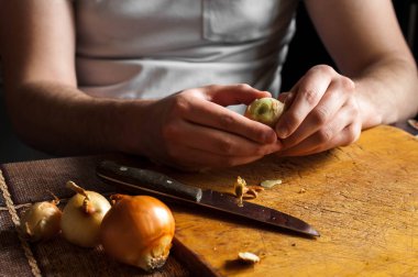 Adam bir bıçak temizler ve soğan kesmek