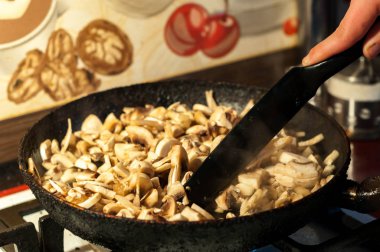 bir tavada soğan ile kavrulmuş mantar