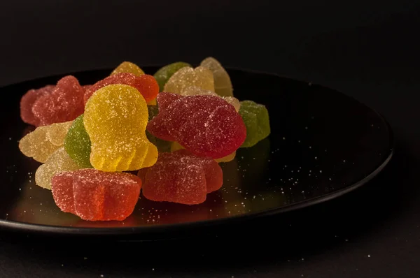 Close-Up Of Colorful Candy. mixed fruit flavoured jellies on a black plate — Stock Photo, Image