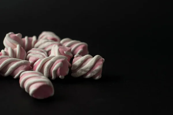 Marshmallows su sfondo nero con copyspace. Lato piatto o vista dall'alto. Sfondo o texture di mini marshmallow colorati . — Foto Stock