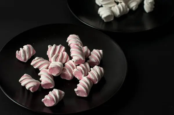 Marshmallows på svart bakgrund med copyspace. Platt lekmanna eller övre vyn. Bakgrund eller konsistens av färgglada mini marshmallows. — Stockfoto