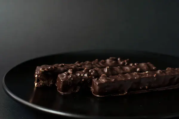 Čokoládové oplatky s ořechy na černém pozadí. — Stock fotografie