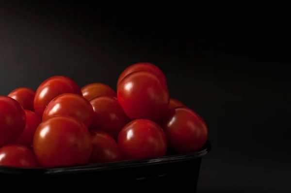 Tomaten auf schwarzem Hintergrund. — Stockfoto