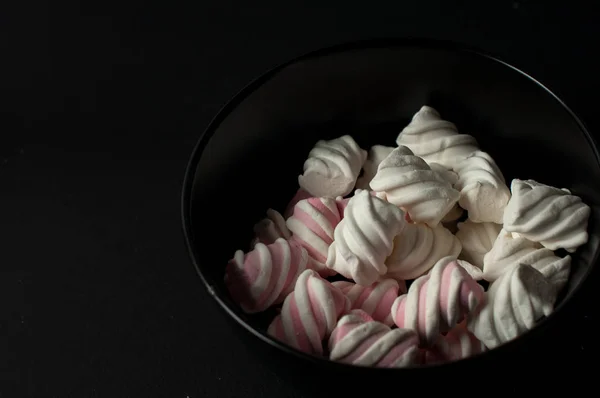 Marshmallows på svart bakgrund med copyspace. Platt lekmanna eller övre vyn. Bakgrund eller konsistens av färgglada mini marshmallows. — Stockfoto