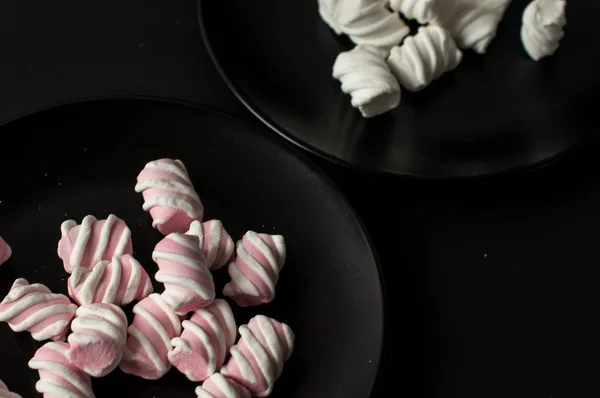 Marshmallows på svart bakgrund med copyspace. Platt lekmanna eller övre vyn. Bakgrund eller konsistens av färgglada mini marshmallows. — Stockfoto