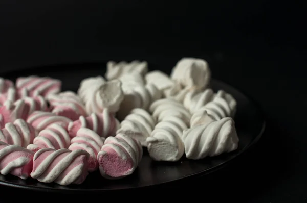 Marshmallows su sfondo nero con copyspace. Lato piatto o vista dall'alto. Sfondo o texture di mini marshmallow colorati . — Foto Stock