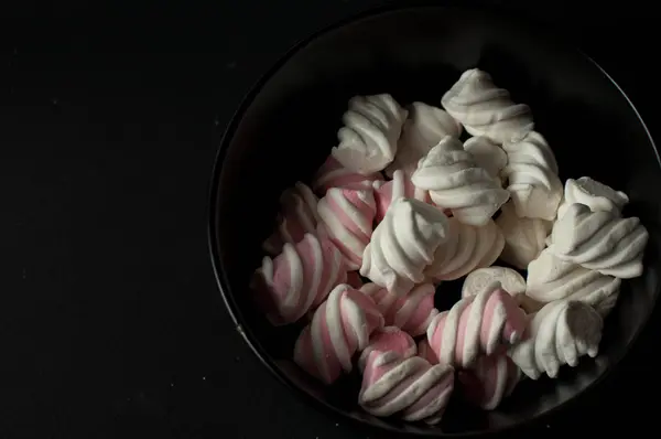 Marshmallows på svart bakgrund med copyspace. Platt lekmanna eller övre vyn. Bakgrund eller konsistens av färgglada mini marshmallows. — Stockfoto