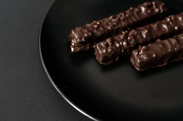 Cialde al cioccolato con noci su fondo nero . — Foto Stock