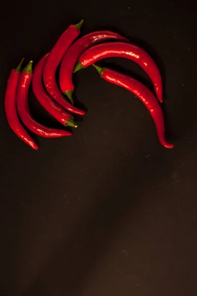Red Chili peppers on a black background — Stock Photo, Image