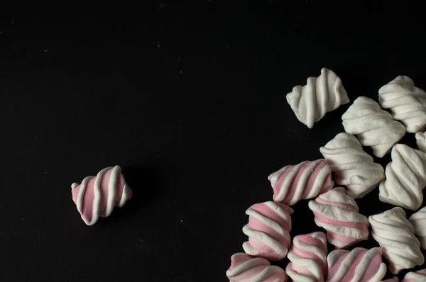 Marshmallows on black background with copyspace. Flat lay or top view. Background or texture of colorful mini marshmallows. — Stock Photo, Image