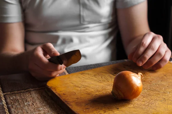 Adam bir bıçak temizler ve soğan kesmek