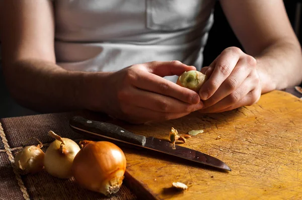 Adam bir bıçak temizler ve soğan kesmek