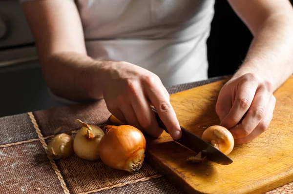 Adam bir bıçak temizler ve soğan kesmek