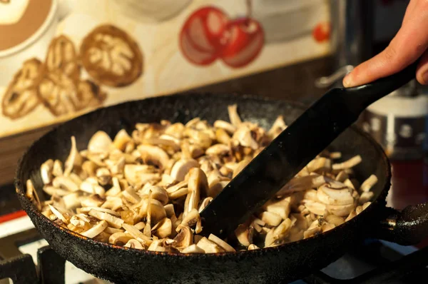 bir tavada soğan ile kavrulmuş mantar