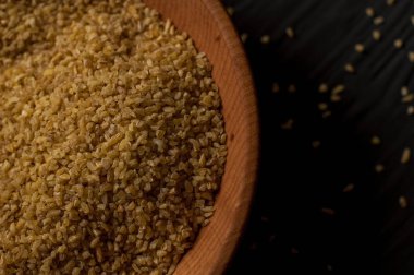 Koyu ahşap izole kahverengi ahşap kase kuru bulgur buğday