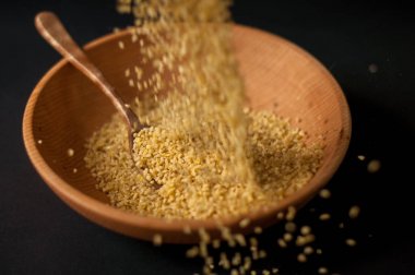 Koyu ahşap izole kahverengi ahşap kase kuru bulgur buğday