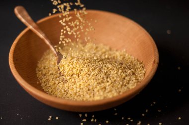 Koyu ahşap izole kahverengi ahşap kase kuru bulgur buğday