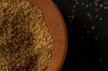 Koyu ahşap izole kahverengi ahşap kase kuru bulgur buğday